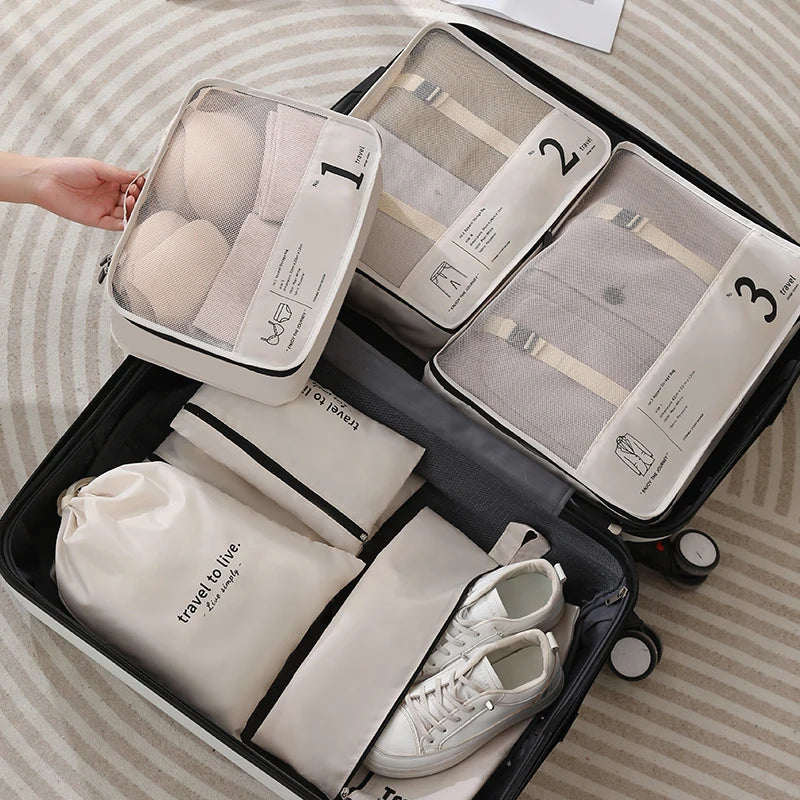 Organisateur de valise 6 pièces beige ouvert avec vêtements rangés